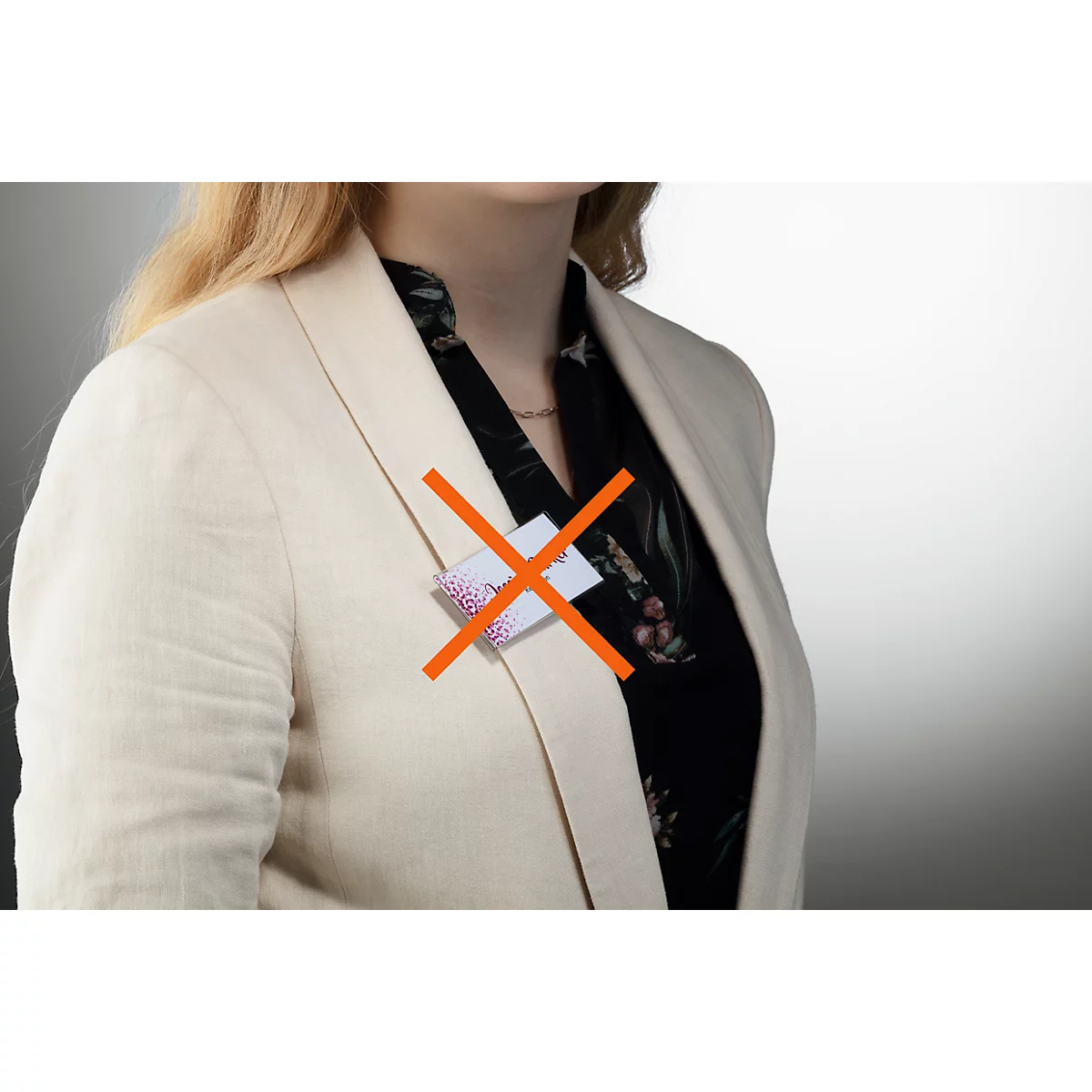 Jonge vrouw met blazer en blouse; een doorgestreepte witte ID-kaart.