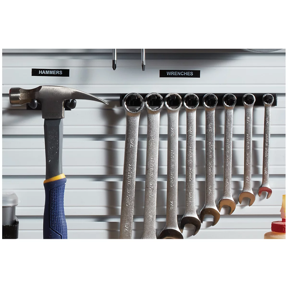 Un marteau et des clés sont suspendus à un mur d'outils. Les étiquettes MARTEAUX et CLÉS sont au-dessus des outils.