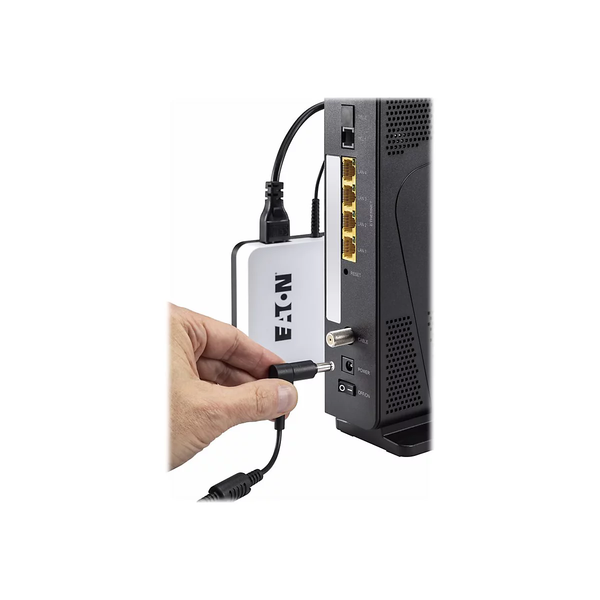 Main branchant un connecteur dans le routeur. Appareil blanc avec le logo Eaton Ã  gauche.