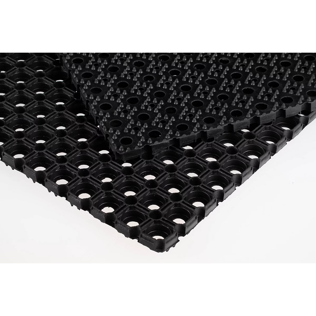 Dos alfombrillas de goma negras superpuestas con un patrón de agujeros cuadrados.