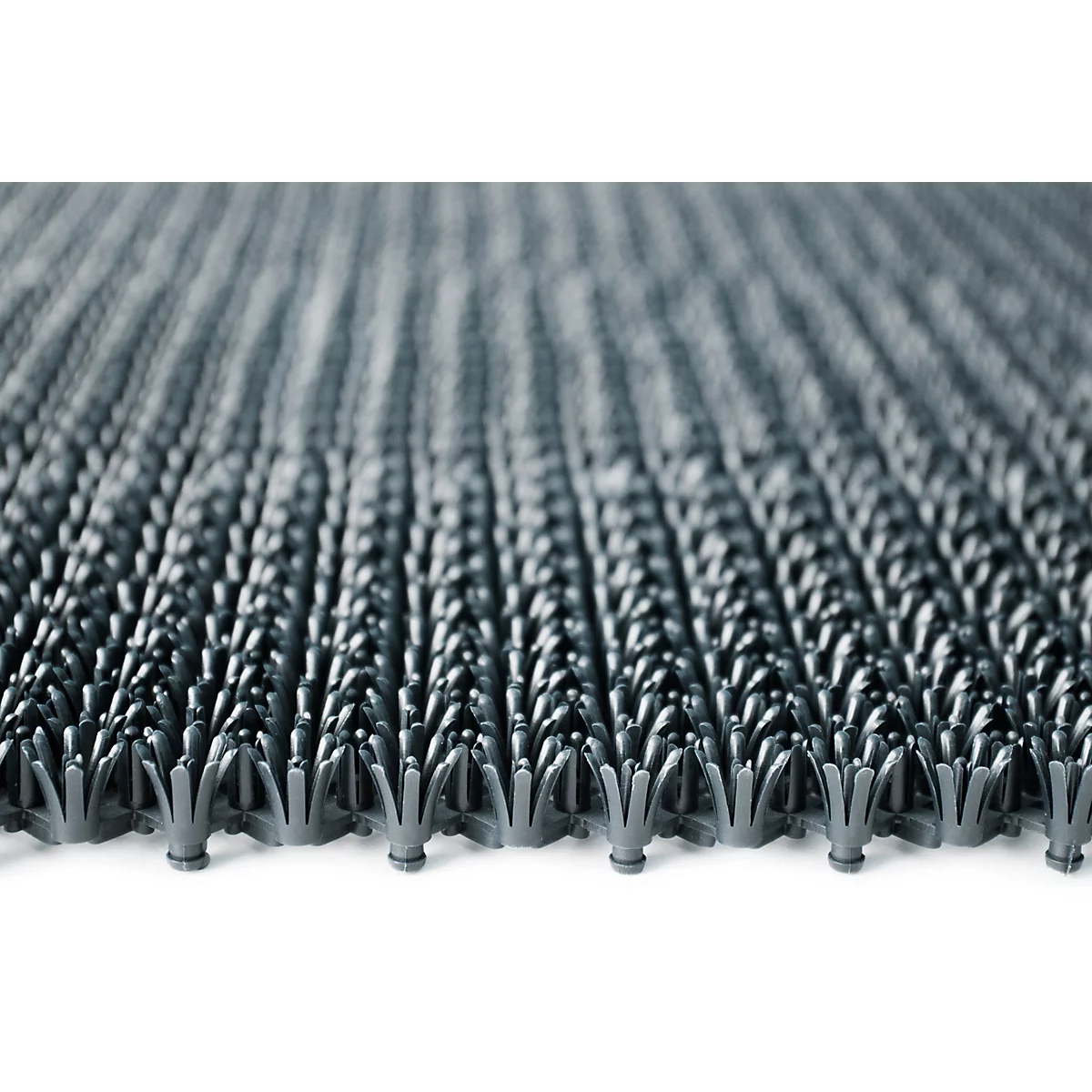 Primer plano de una alfombrilla de plástico gris con muchas láminas pequeñas, puntiagudas y con forma de flor.