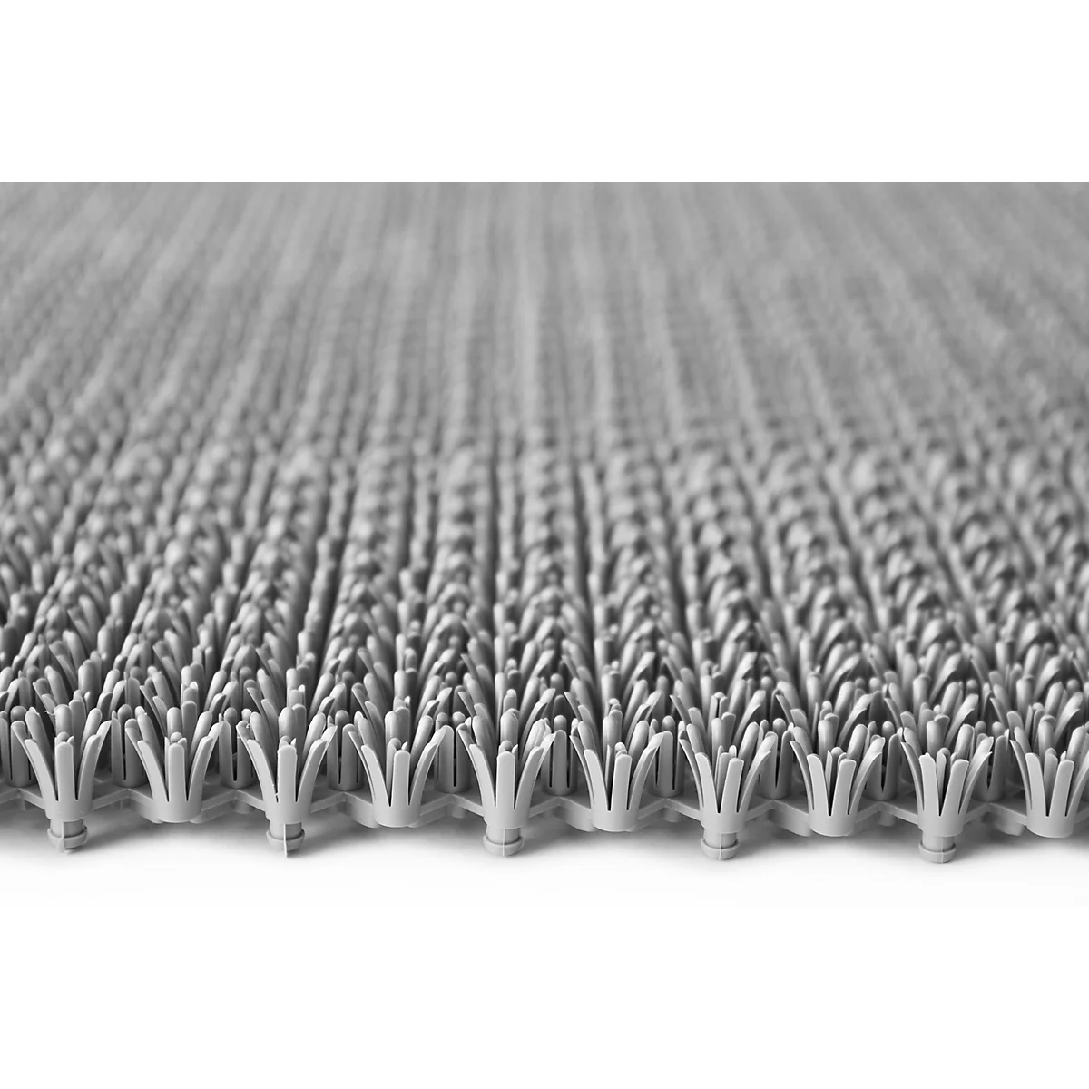 Close-up van een grijze, gestructureerde kunststof mat met borstelachtige elementen.