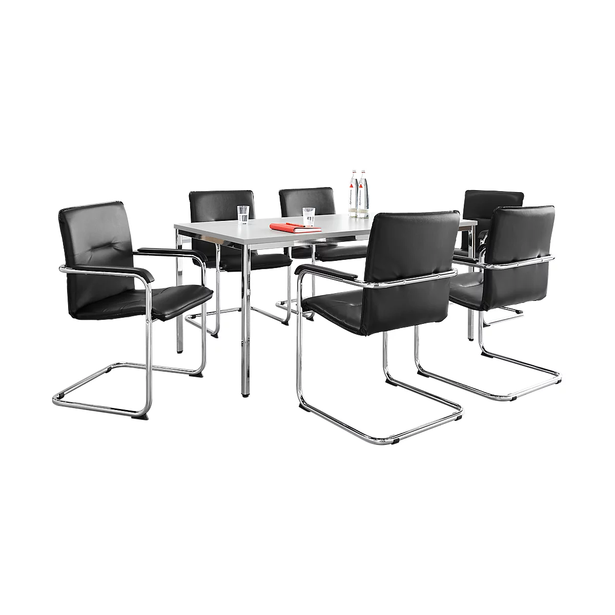 A table with six black leather chairs. On the table are glasses, a bottle and a red book.