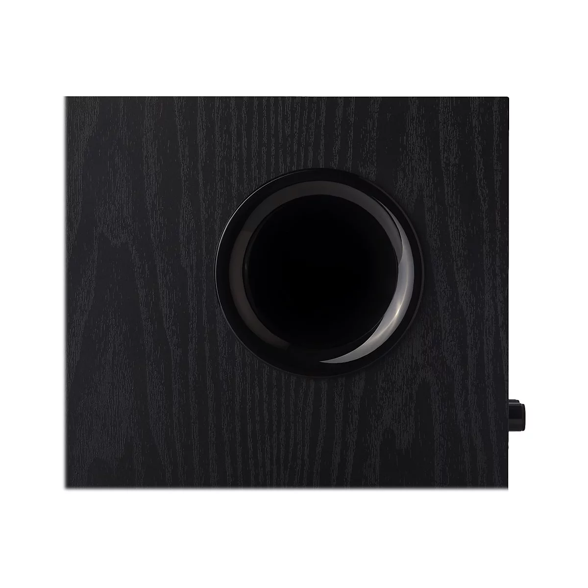 Nahaufnahme der schwarzen Holzoberfläche eines Subwoofers mit mittiger, glänzend schwarzer Lautsprechermembran.
