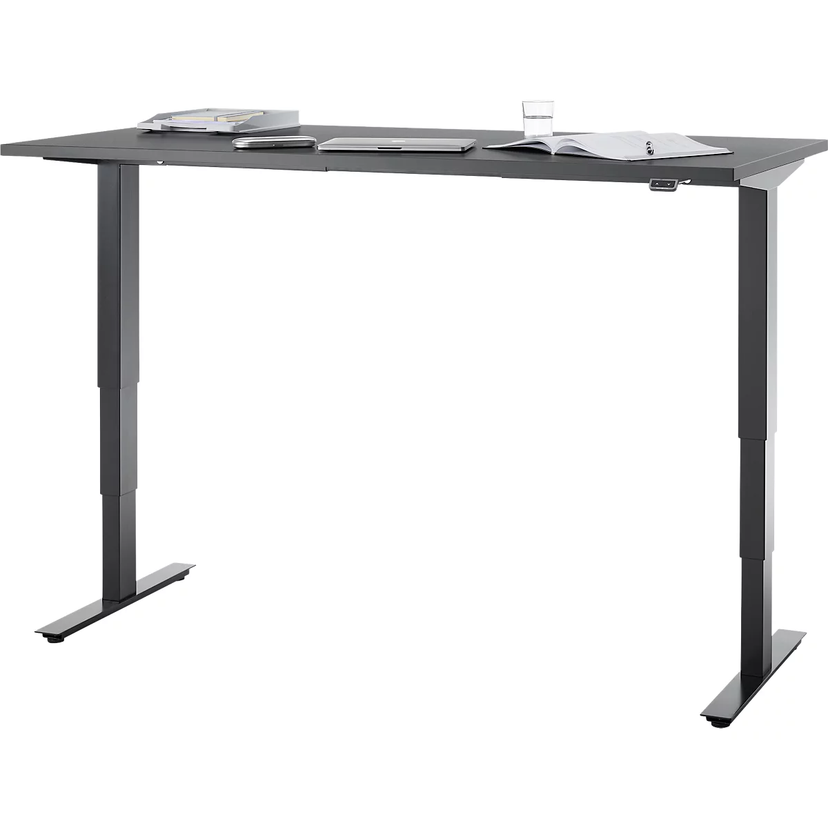 Grauer, höhenverstellbarer Schreibtisch mit Utensilien. Auf der Tischplatte liegen Laptop, Tablet, Notizbuch, Wasserglas.