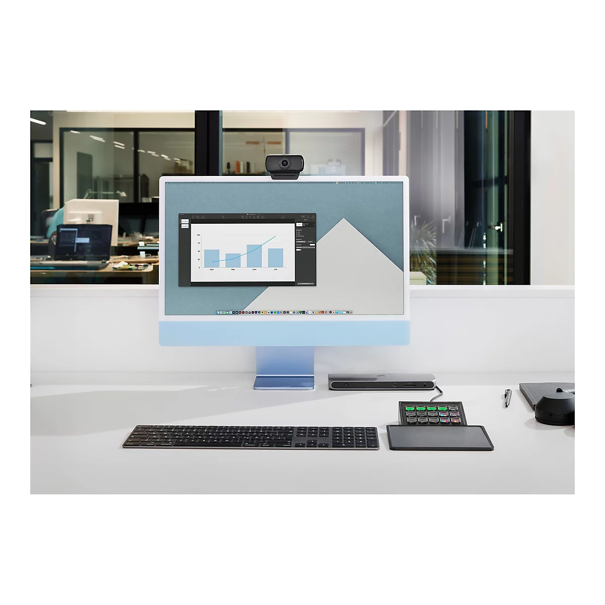 Schreibtisch mit Monitor, Tastatur, Webcam und Zubehör. Diagramm auf dem Bildschirm.