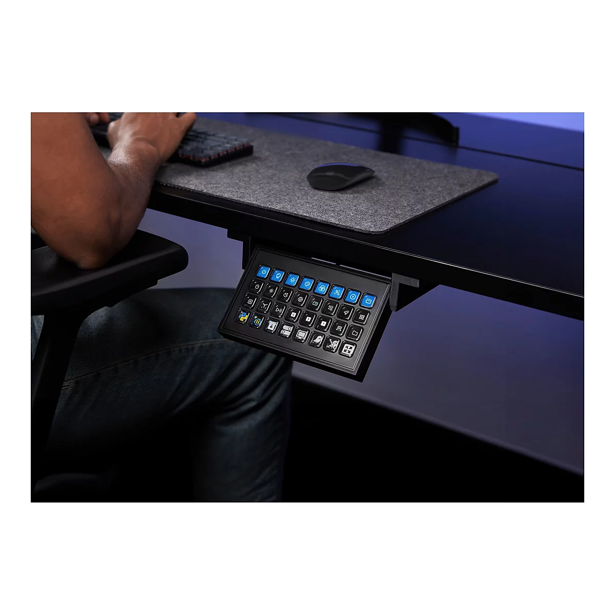 Nahaufnahme eines Benutzers, der ein schwarzes Mini-Keyboard unter einem Schreibtisch bedient. Blaue und weiße Symbole auf den Tasten.