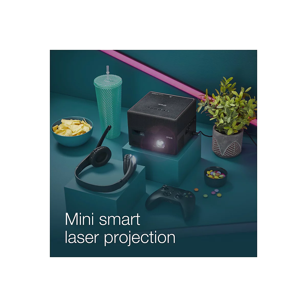Schwarzer Projektor mit Zubehör: Chips, Kopfhörer, Controller, Getränk und Süßigkeiten. "Mini Smart Laser Projection".