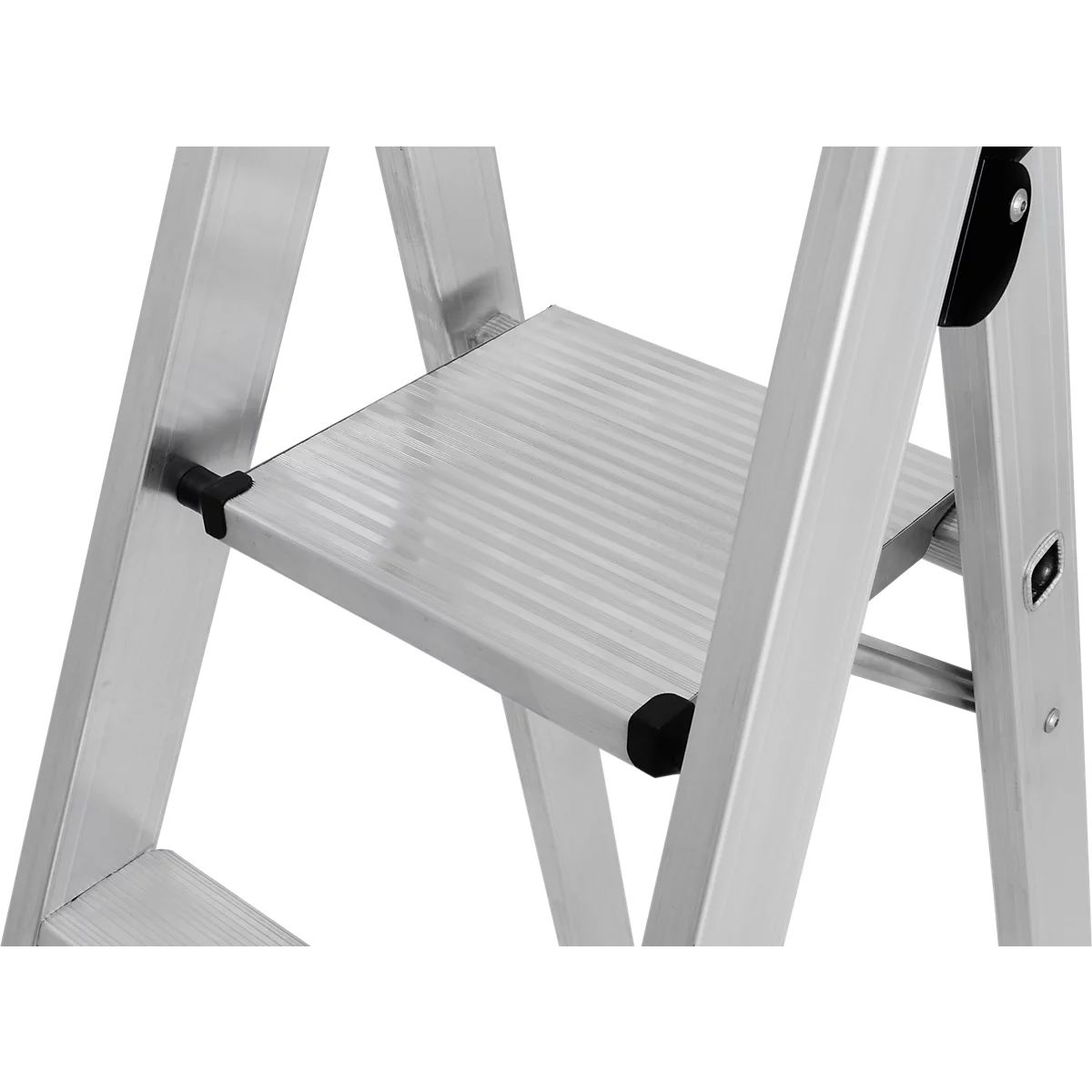 Gros plan d'un escabeau argenté appuyé contre un mur blanc. L'escabeau a des marches striées et des pièces en plastique noir.