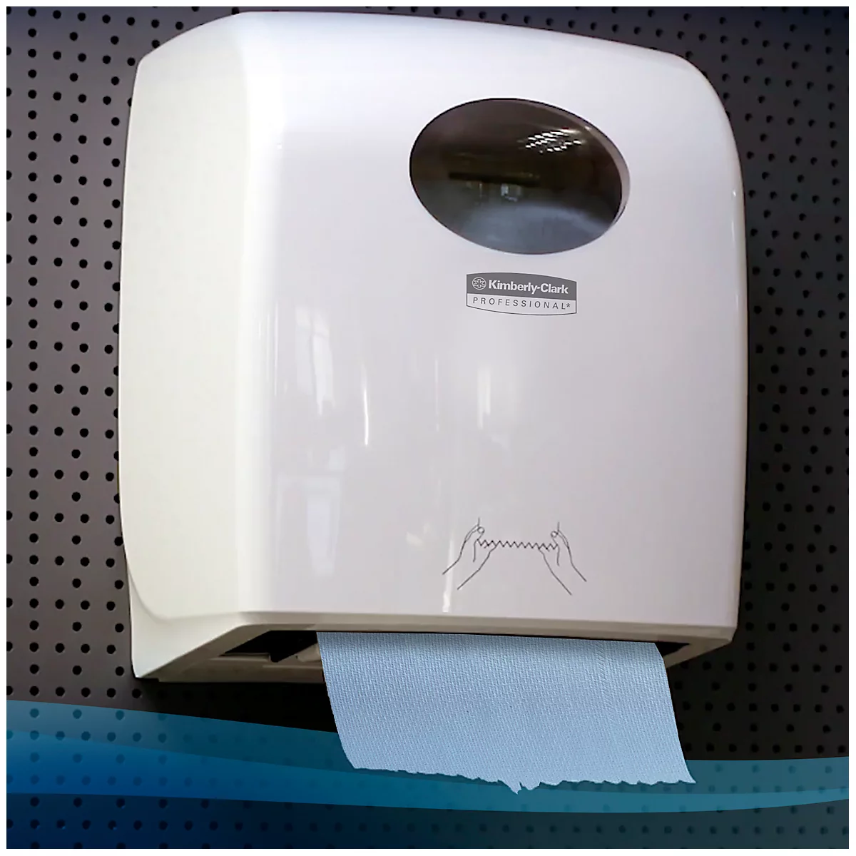 Distributeur d'essuie-mains en papier blanc avec essuie-mains en papier bleu, à côté d'une planche à trous noire.