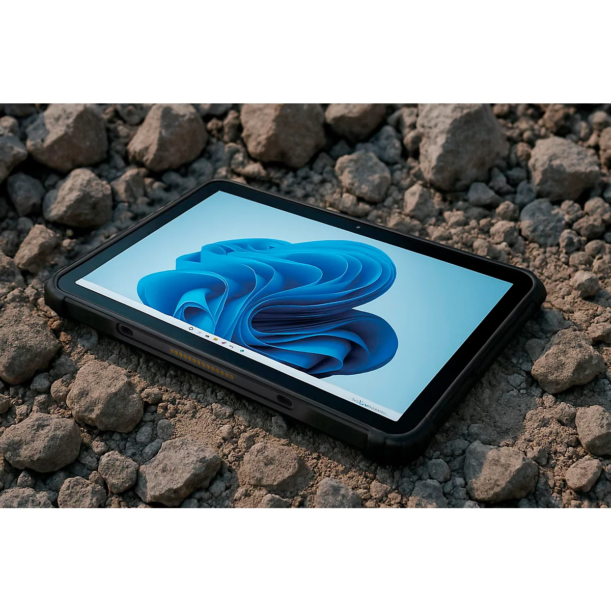 Robustes Tablet mit Windows-Logo auf dem Display liegt auf einem steinigen Untergrund.