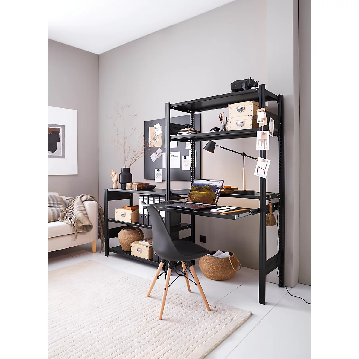 Bureau avec étagère noire, ordinateur portable, chaise et décoration dans un salon moderne. Ambiance chaleureuse.