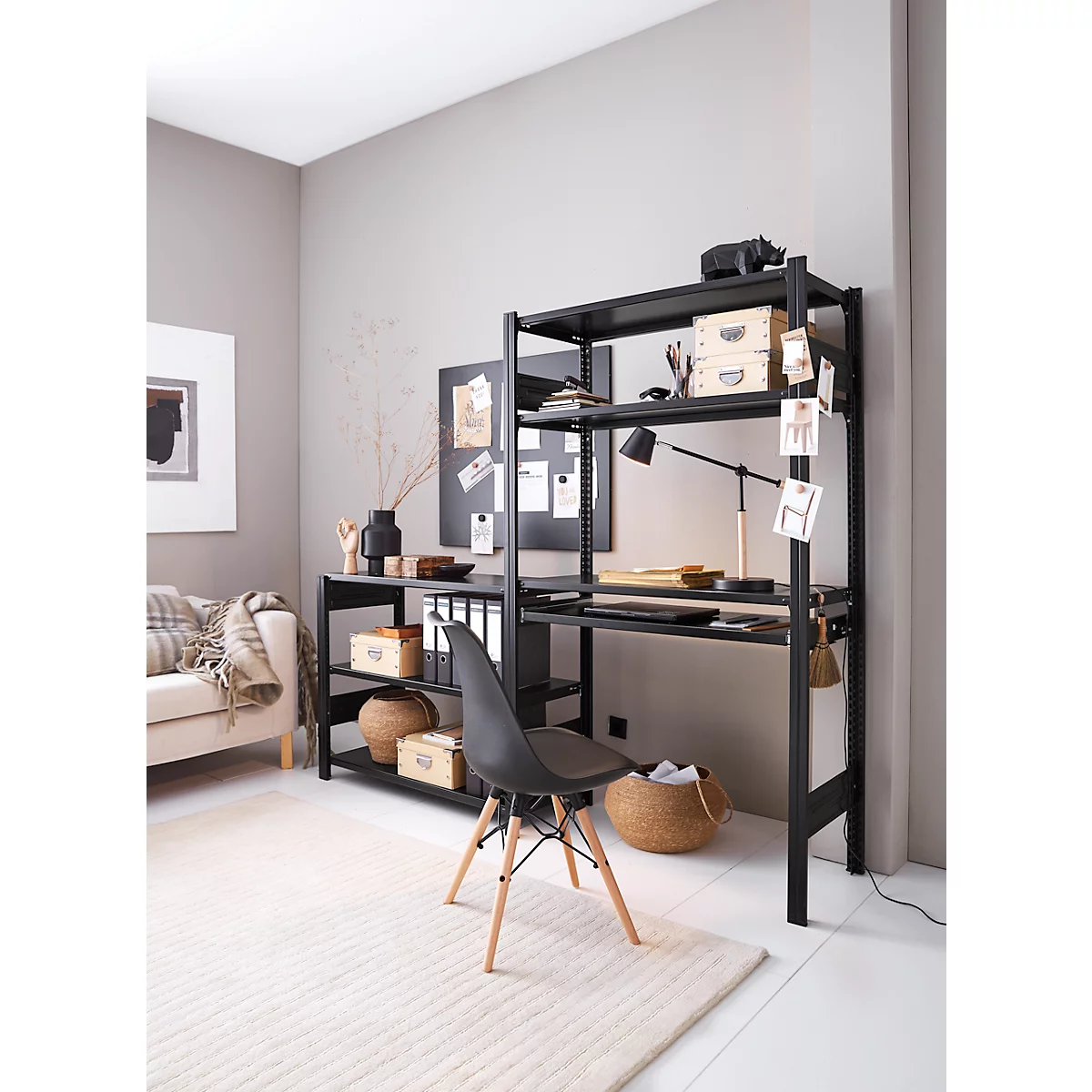 Un bureau noir avec étagères, chaise et décorations dans une pièce lumineuse.