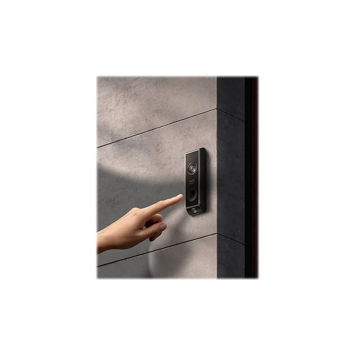 Eine Hand berÃ¼hrt eine schwarze TÃ¼rklingel an einer grauen Wand. Die TÃ¼rklingel hat ein modernes Design und ist rechteckig.