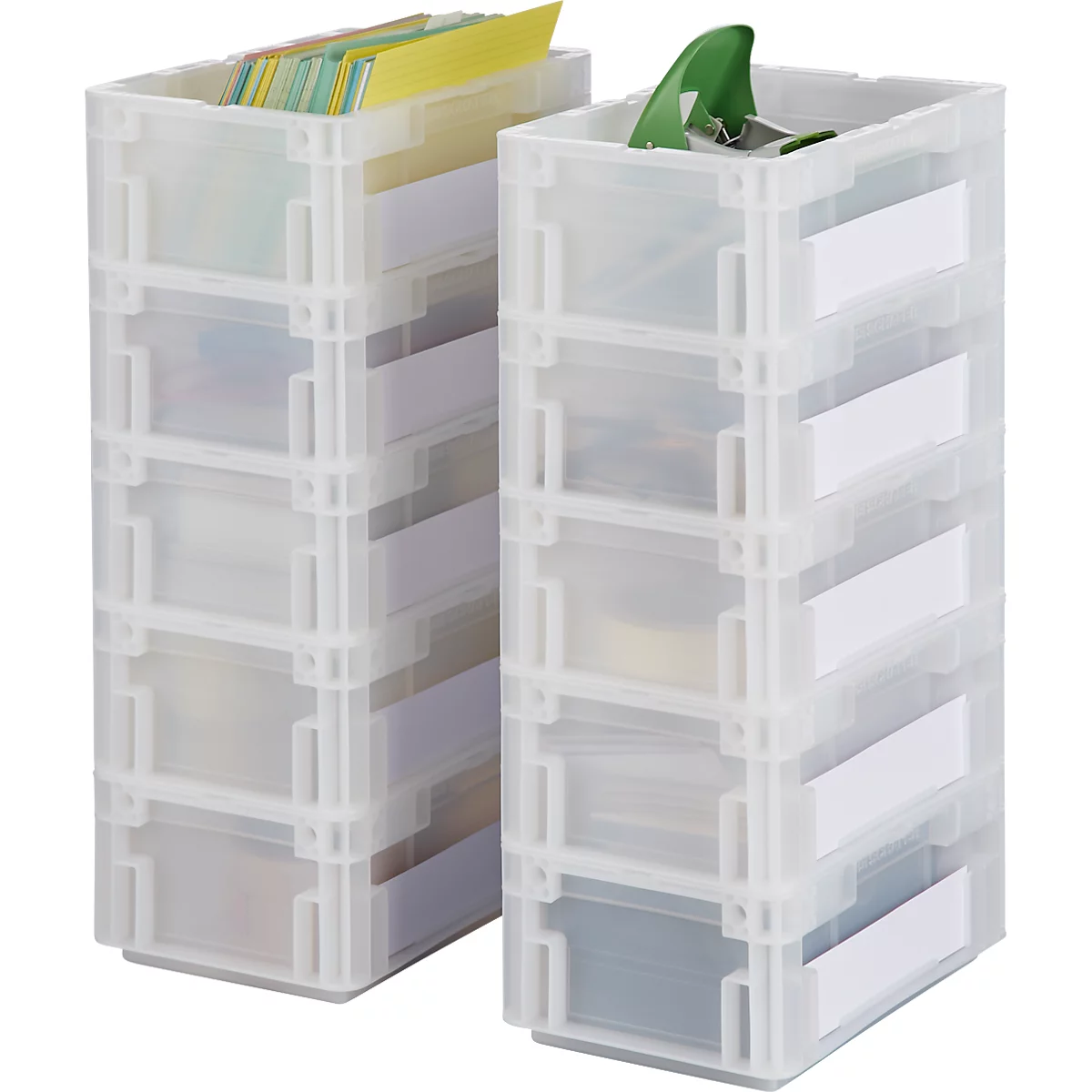 Zwei transparente, stapelbare Aufbewahrungsboxen. Eine Box enthält Karten und die andere grüne Gegenstände. Jede Box hat weiße Etiketten.