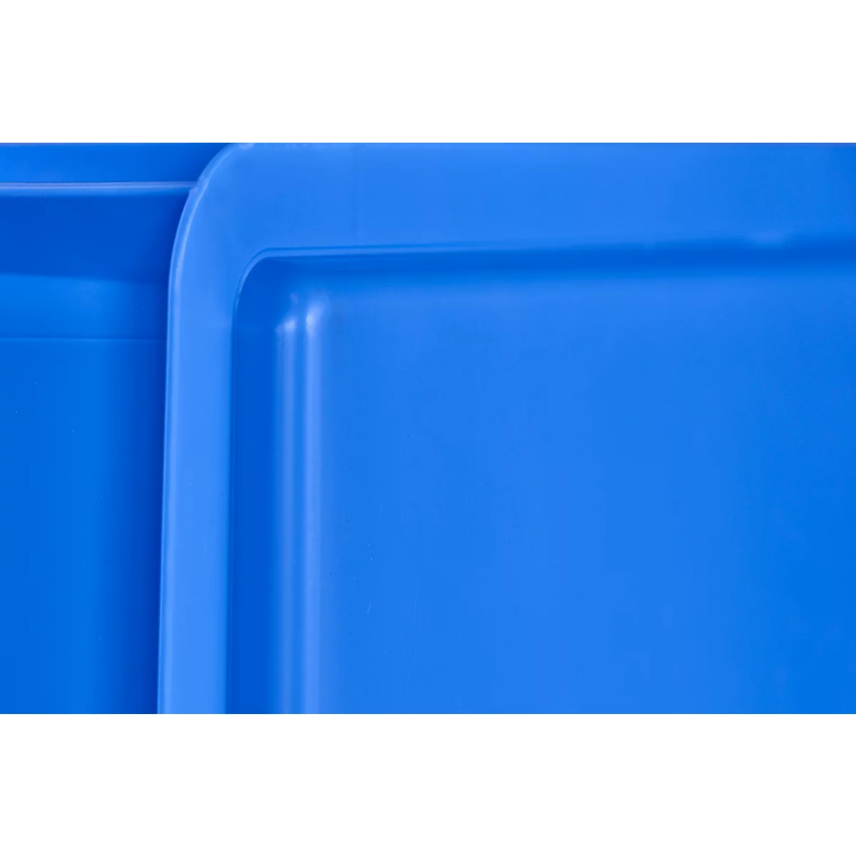 Close-up of bright blue plastic boxes. Rounded corners and edges stand out against the smooth surface.
