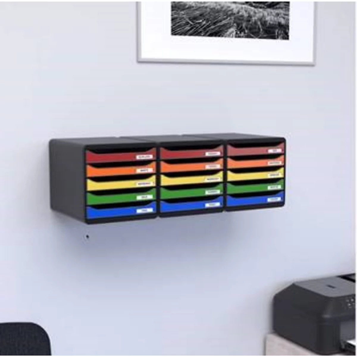 Organiseur mural avec compartiments colorés. Une photo en noir et blanc encadrée est accrochée au-dessus.