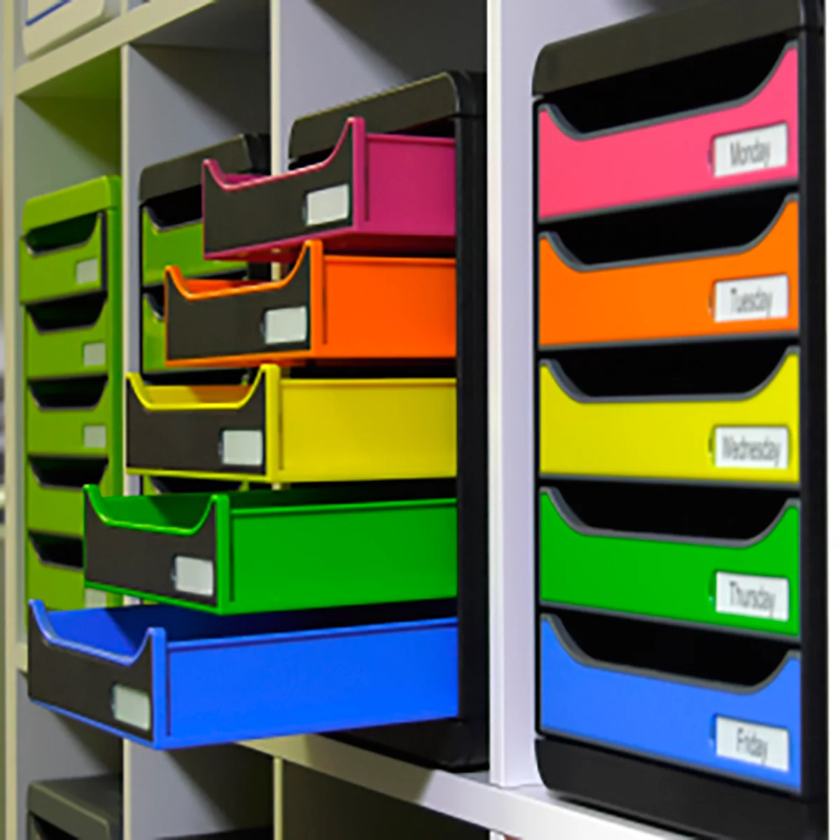 Multicolor lades op de muur, gelabeld met weekdagen, één lade is open.