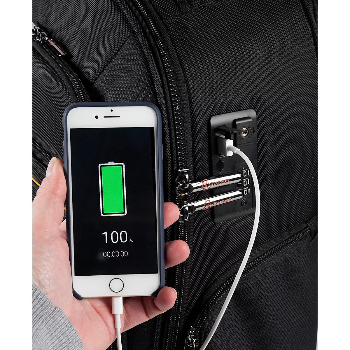 Ein Smartphone wird mit einem Ladekabel an einem schwarzen Rucksack geladen. Auf dem Bildschirm steht "100".