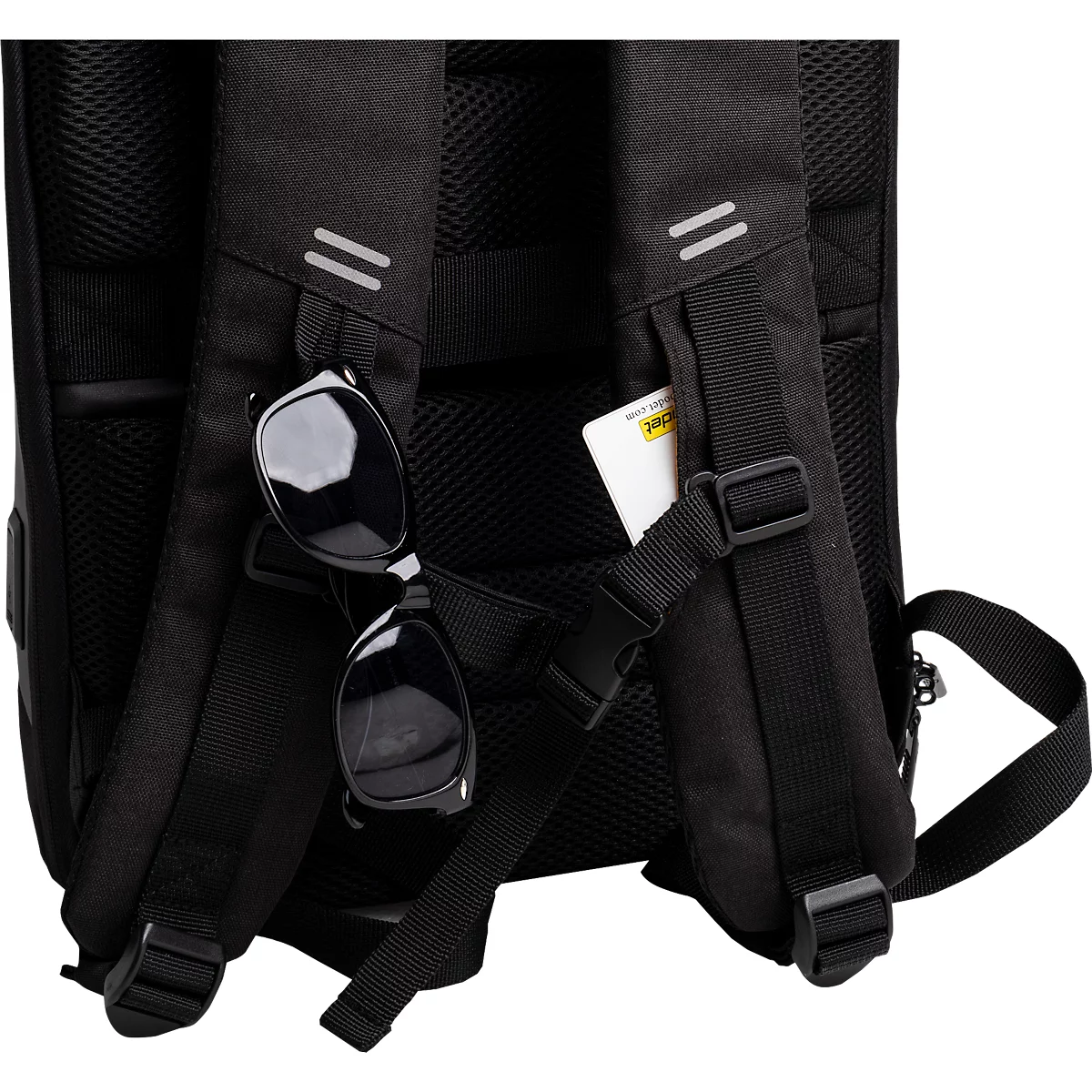Schwarzer Rucksack mit Sonnenbrille, einer Karte und Reflektoren an den Trägern.