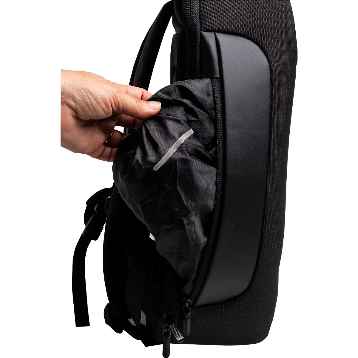 Eine Hand öffnet die Reißverschlusstasche eines schwarzen Rucksacks und zeigt einen schwarzen Beutel mit einem reflektierenden Streifen.