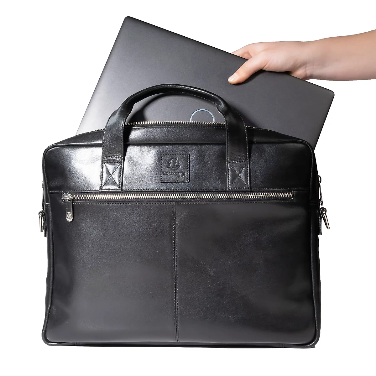 Schwarze Ledertasche, in die ein Laptop gelegt wird. Eine Hand hält den Laptop.