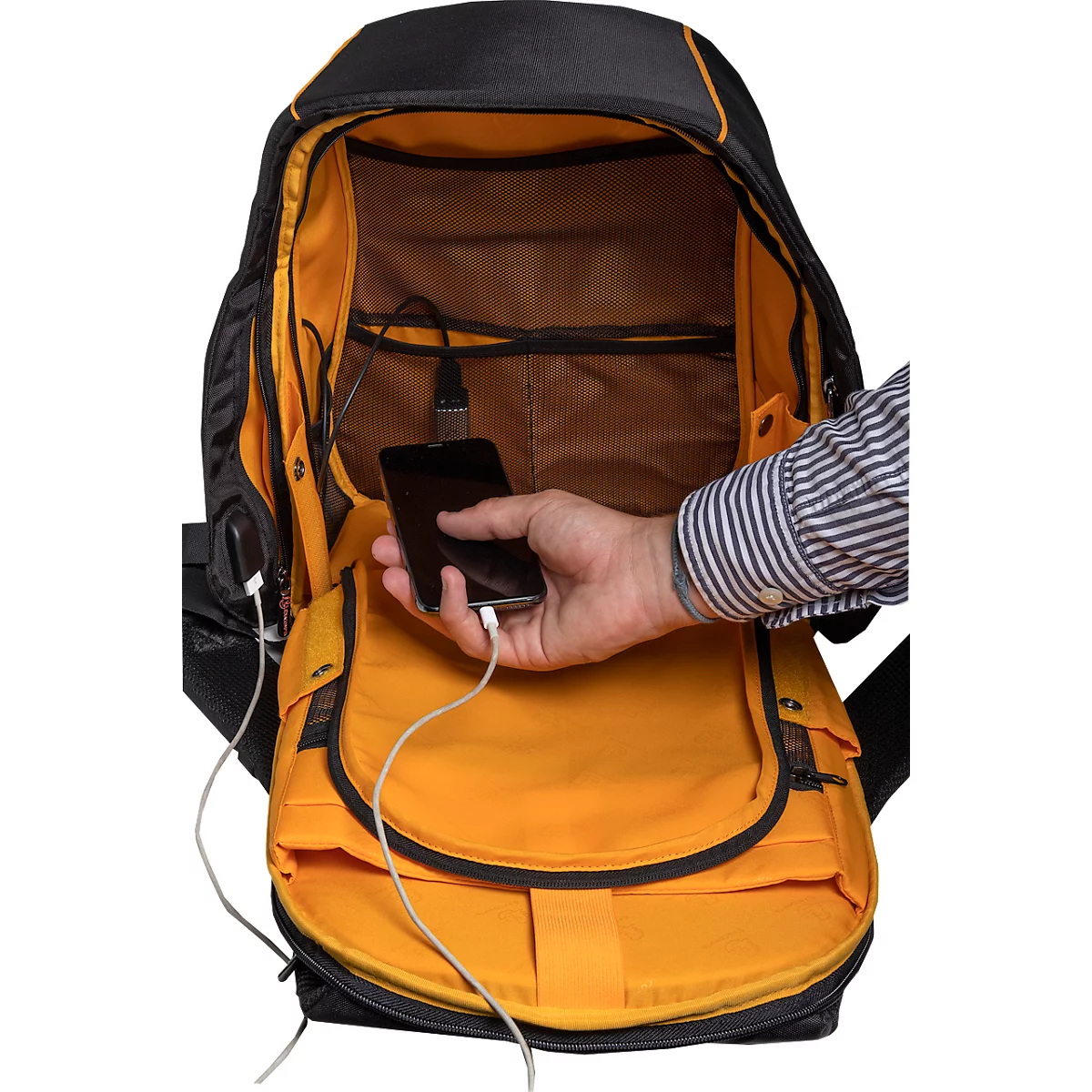 Een man houdt zijn telefoon vast, die via een kabel is aangesloten op een rugzak. De rugzak heeft een gele binnenkant.
