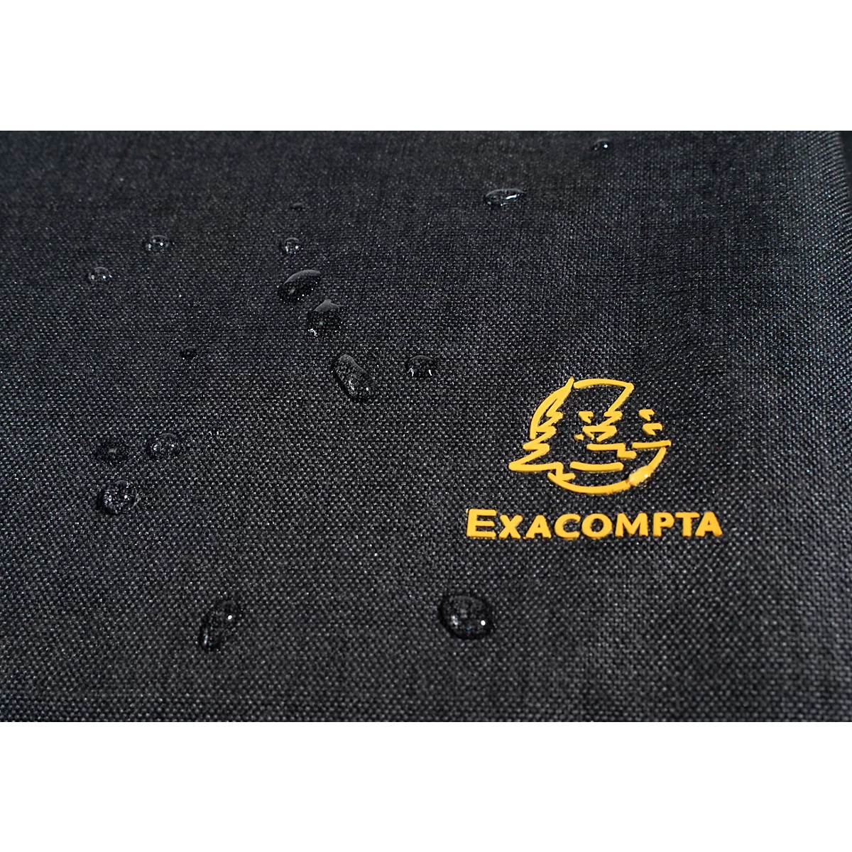 Schwarzes Stoffdetail mit gelbem Logo und Wassertropfen. Text: EXACOMPTA.
