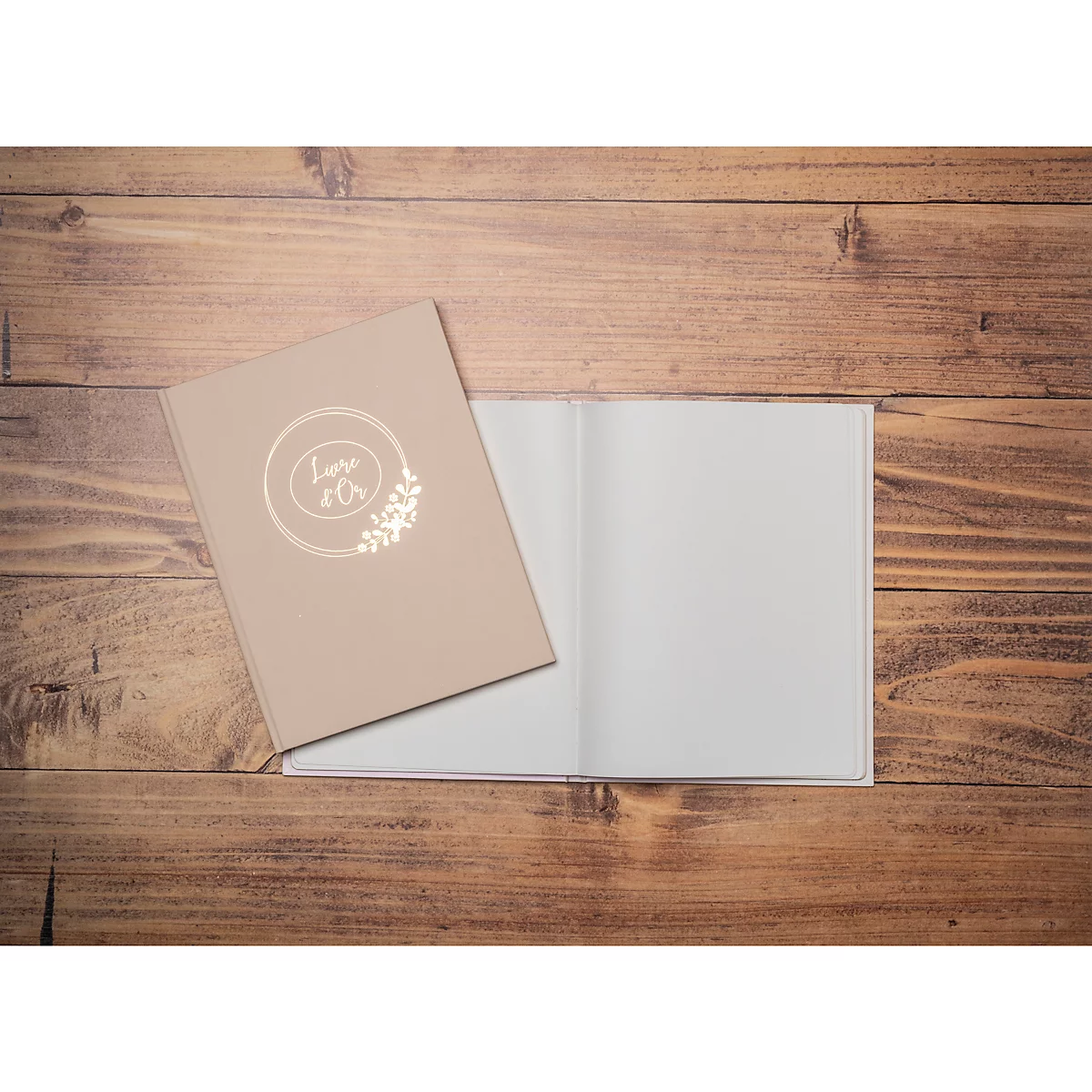 Beiges Buch mit goldenem Logo, offen neben geschlossenem auf Holzgrund. Leere Seiten. Buch hat "Love & Co" Schriftzug.