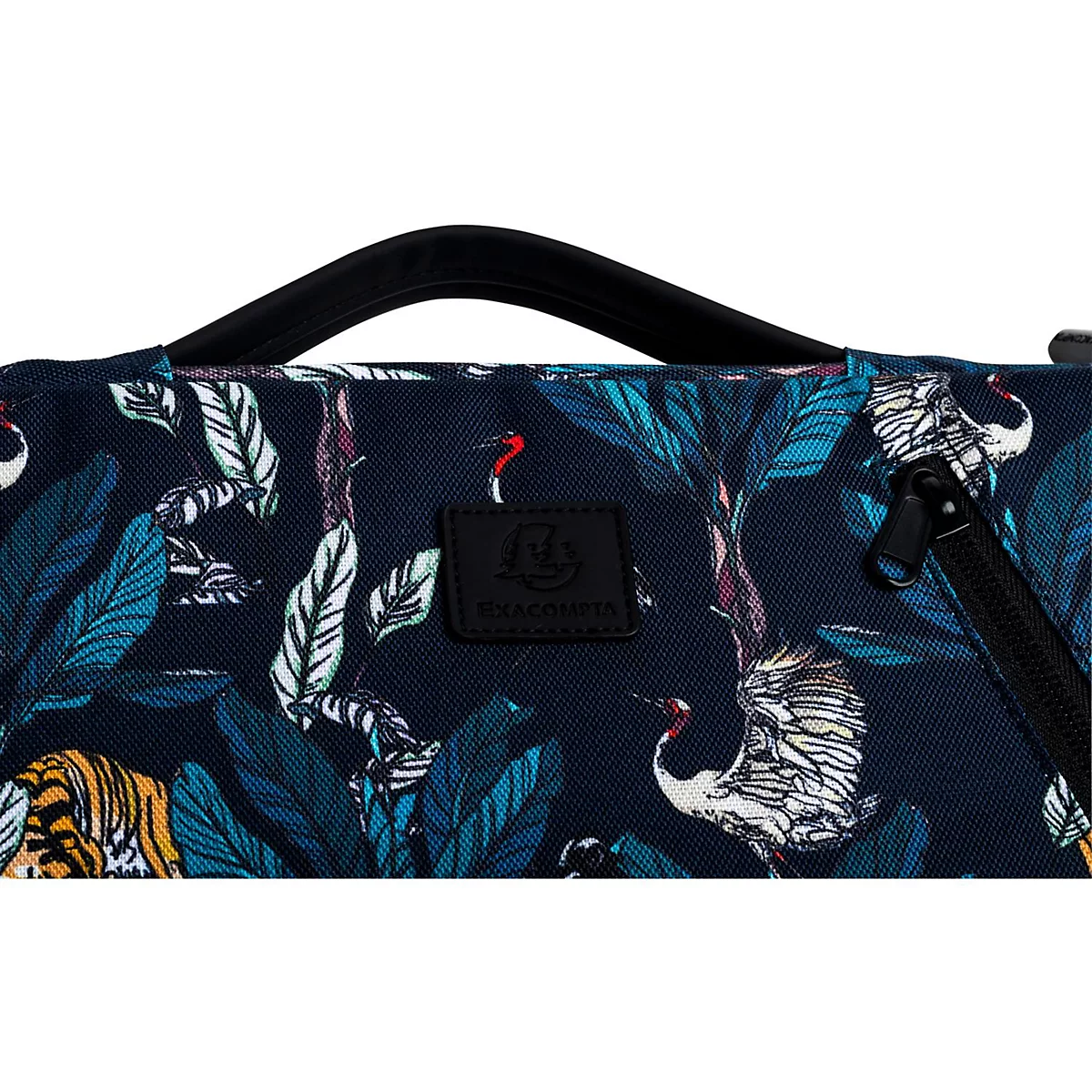 Détail d'un sac avec imprimé exotique de plantes et d'animaux en bleu. Poignée et fermeture éclair noires.