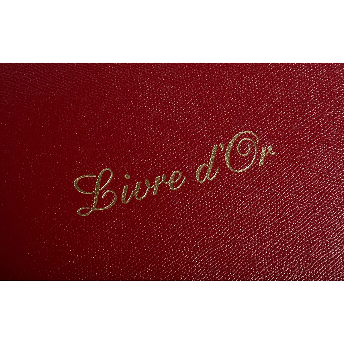 Livre rouge en cuir avec inscription dorée : 'Livre d'Or'.
