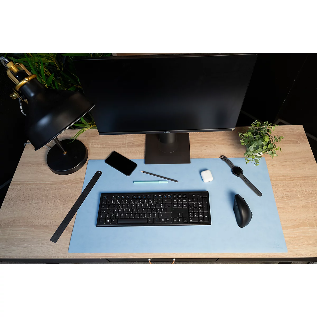 Draufsicht auf einen Schreibtisch mit Monitor, Tastatur, Maus, Uhr, Stift, Handy und Lampe.