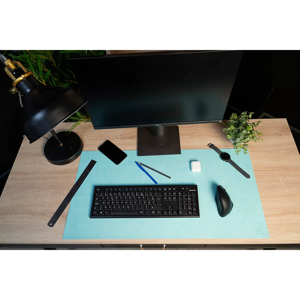 Schreibtisch mit Monitor, Tastatur, Maus, Uhr, Telefon, Stiften, Radiergummi und Lampe.