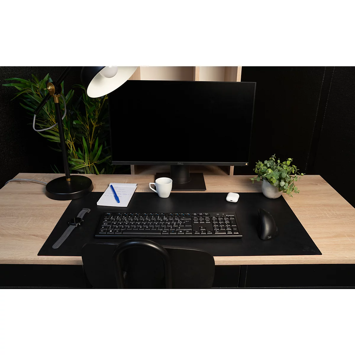 Schreibtisch mit Computer, Tastatur, Maus, Notizblock, Tasse, Kopfhörer und Pflanze.