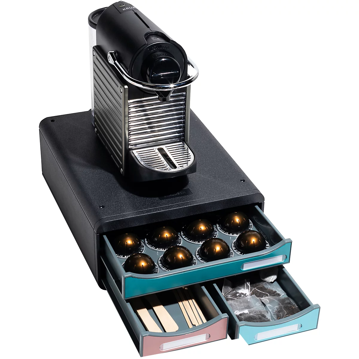 Machine à café avec tiroirs. Une petite machine à café noire repose sur une base noire avec trois tiroirs pour dosettes et accessoires.