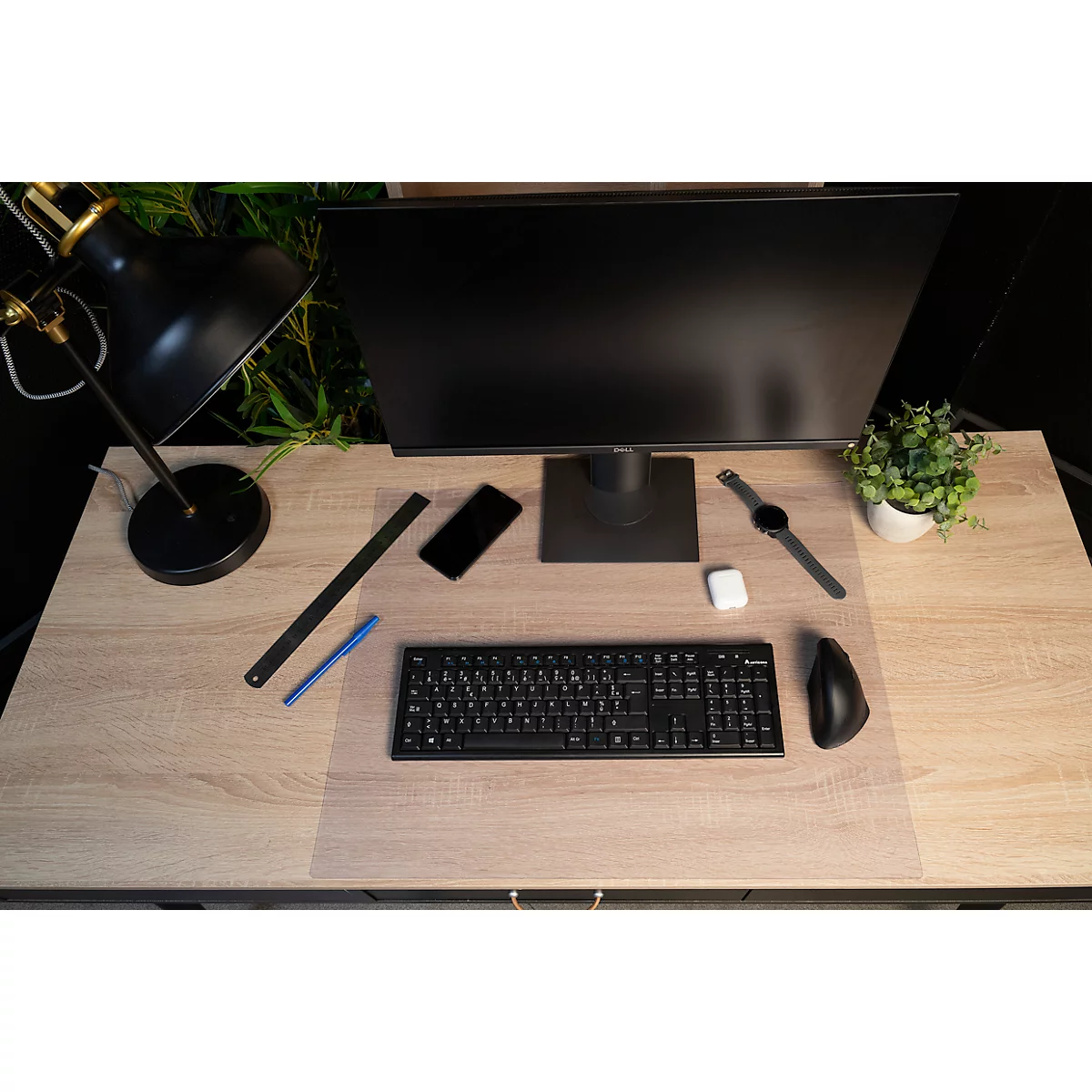 Bureau avec moniteur, clavier, souris, smartphone, écouteurs, smartwatch et lampe.