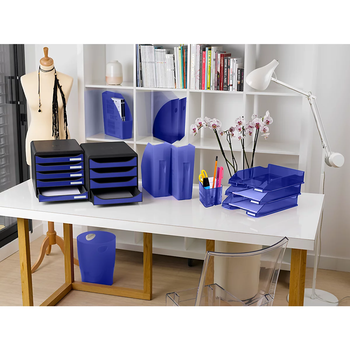 Büro-Schreibtisch mit blauem Bürozubehör: Ablagesysteme, Papierkörbe und Stifthalter.