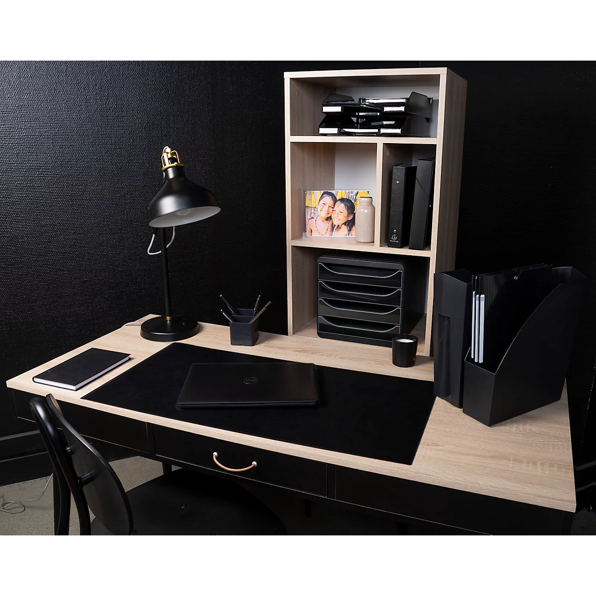 Ein Arbeitszimmer mit Schreibtisch, Lampe, Laptop, Ablage und Büchern. Der Schreibtisch ist mit einem Stuhl, einem Laptop und einem schwarzen Mousepad ausgestattet.