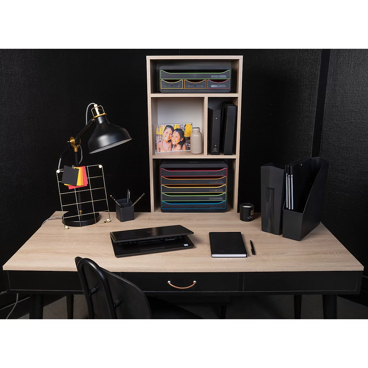 Schreibtisch mit Büromaterial: Schreibtischlampe, Notizblock, Ordner, Schublade und Ablagefächer.