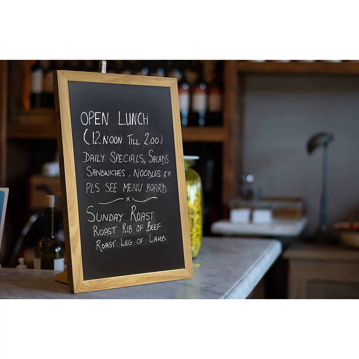 Tableau de menu avec plats du jour, sandwichs et rôti du dimanche. Texte écrit à la craie blanche sur fond noir.
