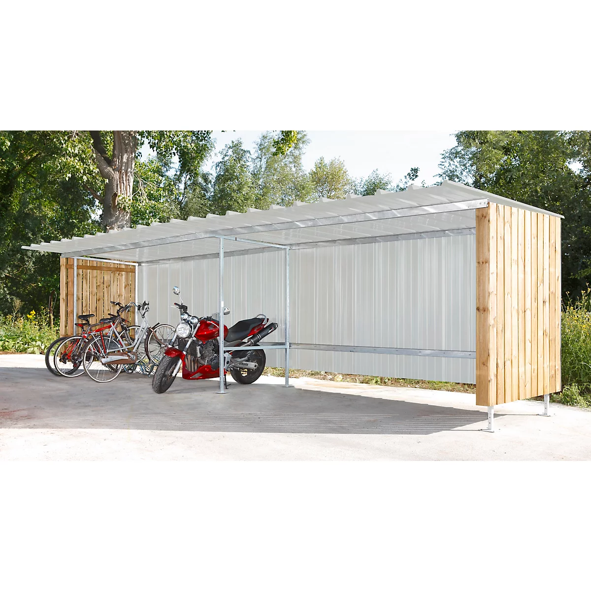 Fahrradunterstand mit Fahrrädern und einem Motorrad. Der Unterstand hat ein Metallgerüst und Seitenwände aus Holz und Metall. Bäume im Hintergrund.