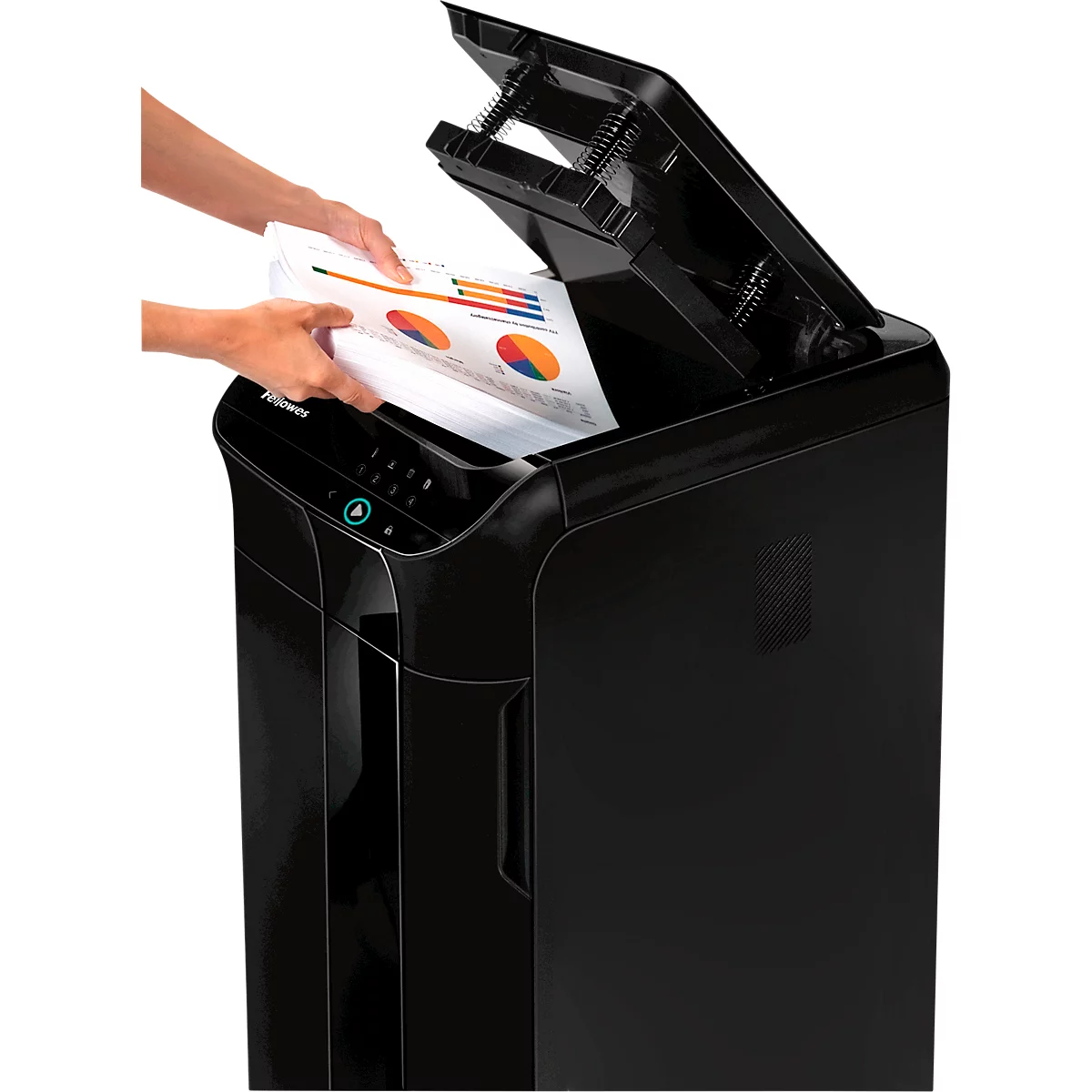 A person placing a chart into a black paper shredder. The lid is open. The paper is marked with colorful pie charts.