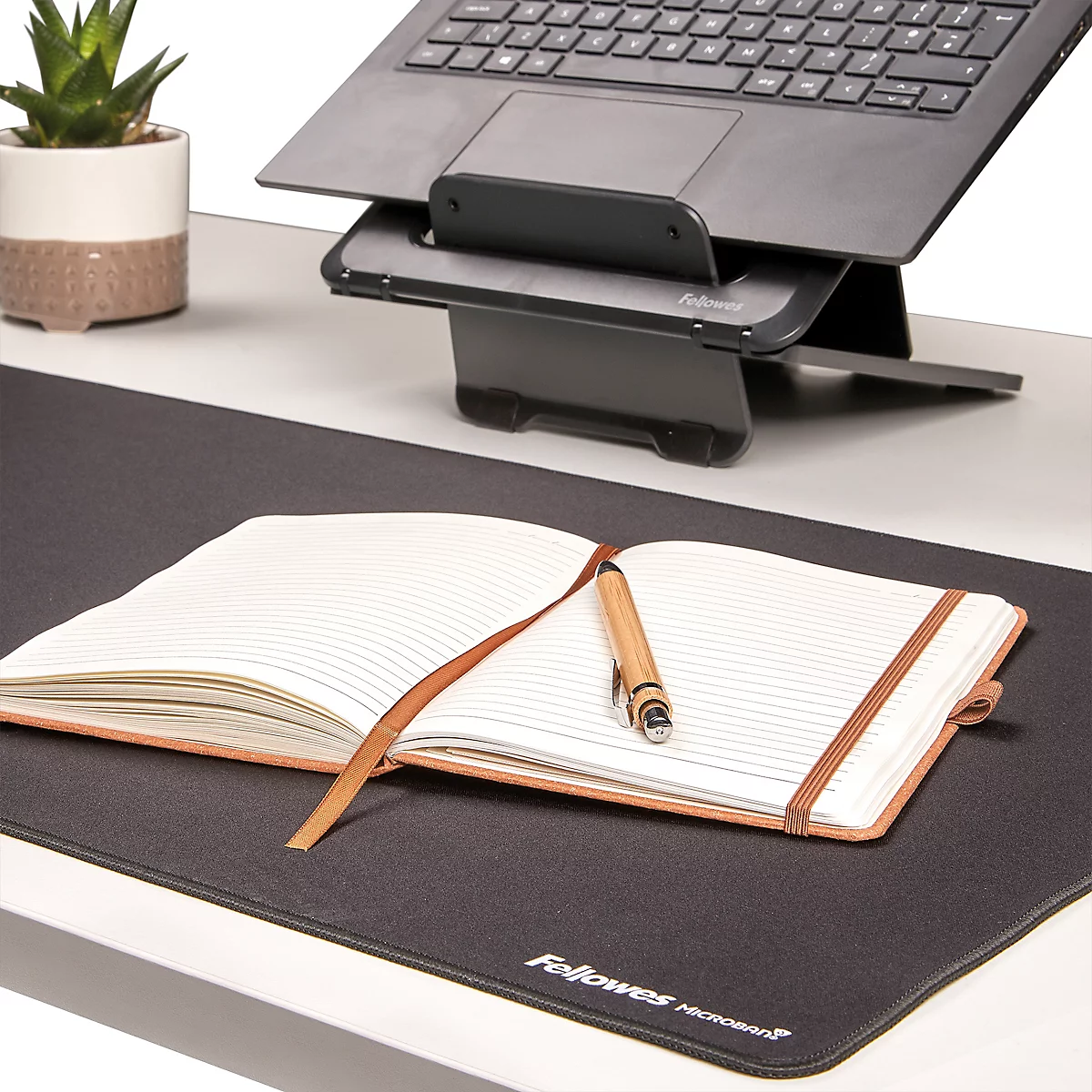 Rolled mousepads in different colors, with the Fellowes Microban logo.