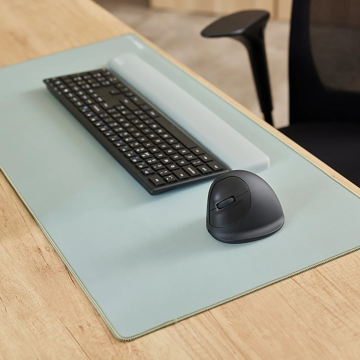 Dunkelgraue, ergonomisch geformte Maus. Kleine Erhebungen auf einer Seite. Abgerundete Form mit breiter Basis.