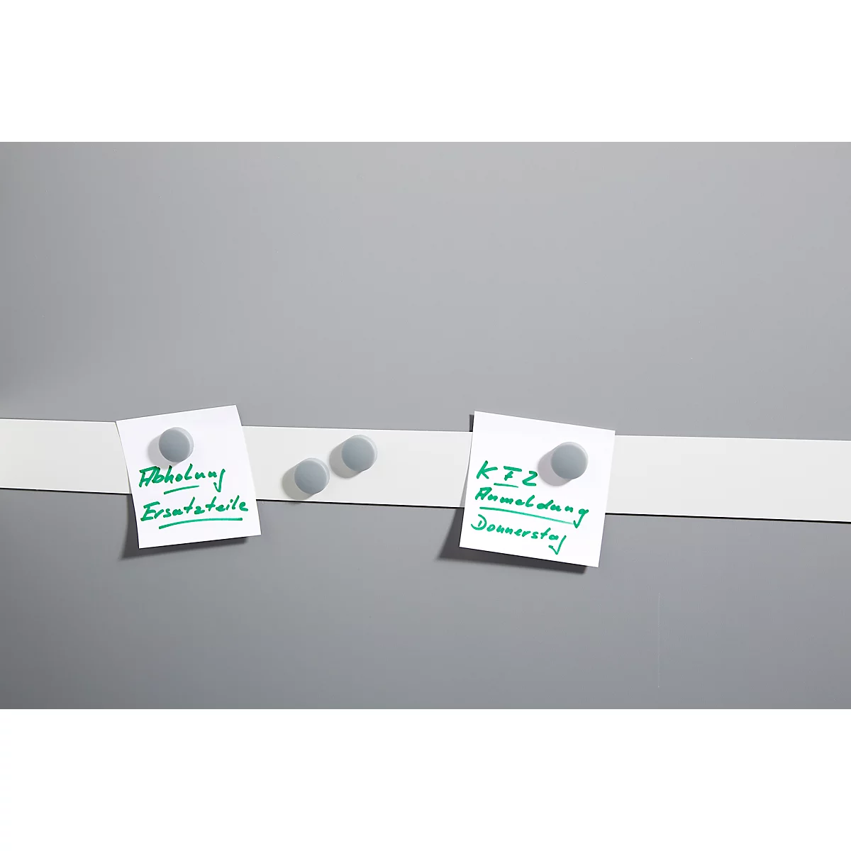 Grey board with white stripe, on which two note pads with green writing adhere. One shows "Collection spare parts", the other "KTZ registration Thursday".