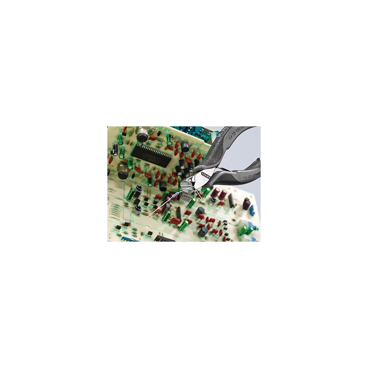 Une pince coupante coupe un fil sur une carte de circuit imprimé. Le fond montre des composants électroniques.