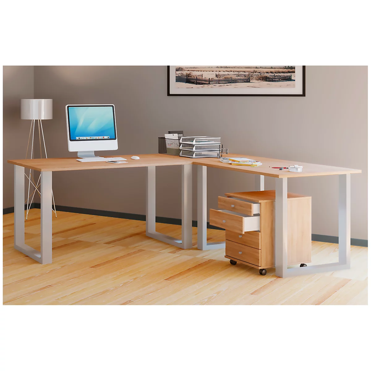 Light wood desk with computer monitor, rolling cabinet, and lamp.