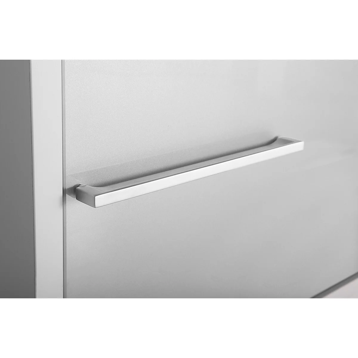 Close-up of a silver handle on a white surface. The handle is flat and rectangular, with rounded edges.