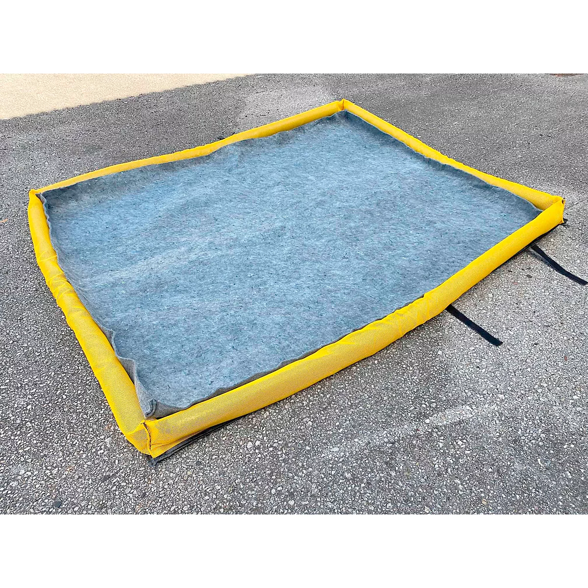 Gele opvangbak met grijs vilt op beton. Zwarte riemen. Vierkante vorm.