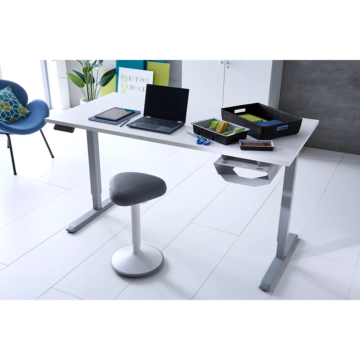 Ein moderner, weißer, höhenverstellbarer Schreibtisch mit Laptop und Zubehör in einem hellen Büro.